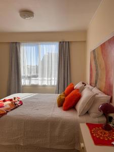 a bedroom with a bed with pillows and a window at Club Retro in Hawera