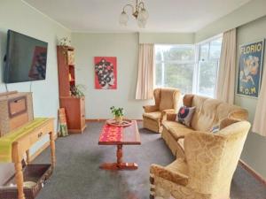 a living room with two couches and a television at Club Retro in Hawera +14 photos