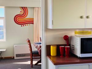 a kitchen with a counter top with a microwave at Club Retro in Hawera