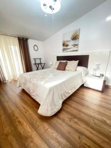 a bedroom with a large bed and a wooden floor at Casa da Xastra in Vimianzo