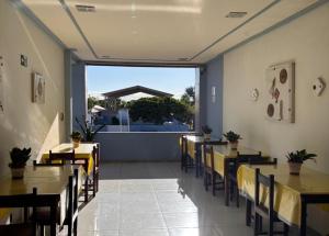 a restaurant with tables and chairs and a large window at RESTAURANTE POUSADA E ESCUNA RIO SOl in São João da Barra
