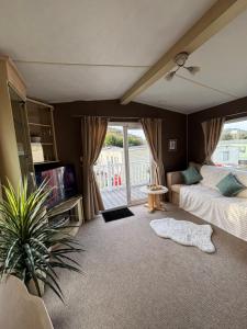 a bedroom with a bed and a tv and a window at Welsh Bay Hideaway 2 bed caravan with sun deck in Aberystwyth