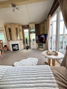 a living room with a bed and a table at Welsh Bay Hideaway 2 bed caravan with sun deck in Aberystwyth