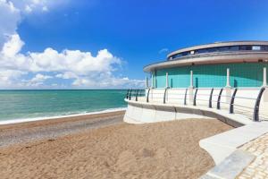 a building on a beach next to the ocean at Welsh Bay Hideaway 2 bed caravan with sun deck in Aberystwyth