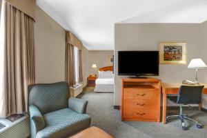 a hotel room with a television and a bed at Prairie Crest Red Deer by IHG in Red Deer