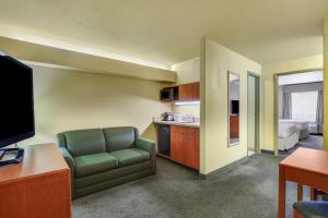 a room with a couch and a kitchen with a bed at Prairie Crest Red Deer by IHG in Red Deer