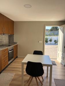 a kitchen with a table and two chairs at Casa papillon in Outeiro