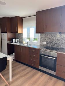 a kitchen with brown cabinets and a stove top oven at Casa papillon in Outeiro +2 photos