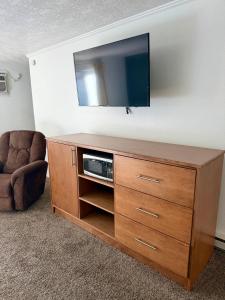 a entertainment center with a flat screen tv and a chair at Bristlecone Motel in Ely