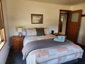 ein Schlafzimmer mit einem Bett und einem Spiegel in der Unterkunft Zeehan Affect in Zeehan