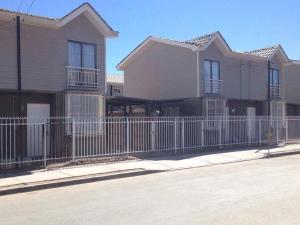 a house with a fence in front of it at Casas Amobladas y Equipadas Calama in Calama
