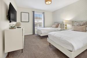 a bedroom with two beds and a flat screen tv at 1556 PD - Poolside Bliss: Enchanted 4BR Townhome in Davenport