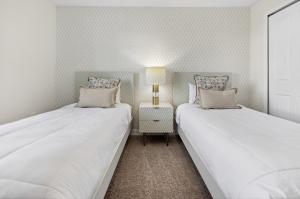 two beds sitting next to each other in a bedroom at 1556 PD - Poolside Bliss: Enchanted 4BR Townhome in Davenport +64 photos