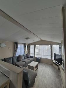 a living room with a couch and a tv at 2 bedroom, robin Hood rhyl in Rhyl