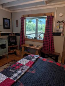 a bedroom with a bed and a window with curtains at Magnolia Cottage Bigfoot Hideaway in Hope