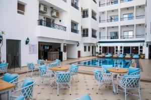 a patio with tables and chairs next to a swimming pool at Swiss Wellness Boutique Hotel Hurghada in Hurghada +39 photos