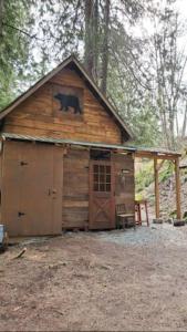 a large wooden cabin with a bear on the roof at Magnolia Cottage Bigfoot Hideaway in Hope +13 photos