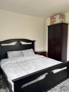 a bedroom with a black bed and a wooden cabinet at Saeeds apartment in Ajloun