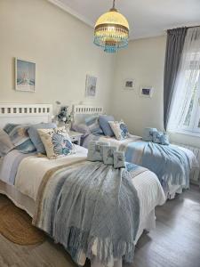 a bedroom with two beds and a chandelier at A un paso de Bilbao in Galdakao