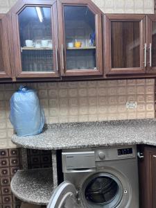 a kitchen with a washing machine under a counter at Saeeds apartment in Ajloun +50 photos