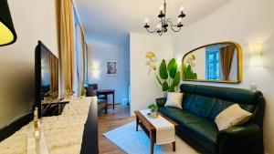 a living room with a green couch and a tv at FewoZauber "Pension am Dom", Historische Apartments, Superzentral, 7min zum Schloss in Schwerin