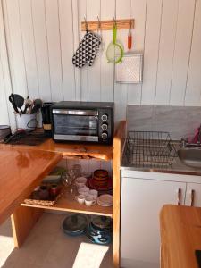 a kitchen with a microwave on a wooden counter at La Ola Tiny House in Maitencillo +11 photos