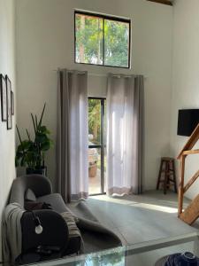 a living room with a chair and a window at Chalé Rio das Pedras in Santo Antônio do Pinhal +30 photos