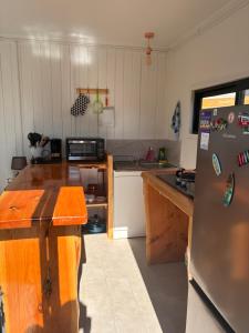 a kitchen with a refrigerator and a counter top at La Ola Tiny House in Maitencillo