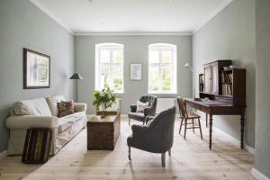 a living room with a couch and a piano at Leuchtturnwohnung in Pommerby +2 photos