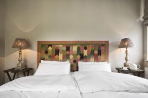 a bed with two white pillows and two lamps at Leuchtturnwohnung in Pommerby