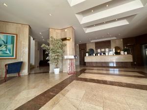 a lobby with a plant in the center of a building at Chateau Linza Resort in Tirana +88 photos