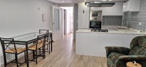 a kitchen with a table and chairs and a counter at Adosado en Casco Antiguo con piscina in Altea