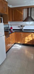 a kitchen with wooden cabinets and a white refrigerator at Casa del Sol Miramar in Miramar +12 photos