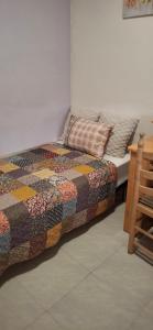 a bed with a quilt and a pillow on it at Casa del Sol Miramar in Miramar