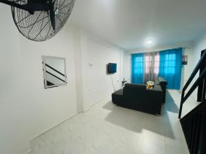 a living room with a black couch and blue curtains at Luanda City Hostel in Luanda