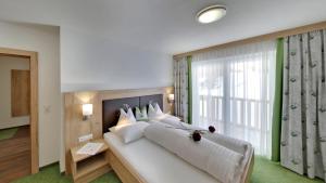 ein Schlafzimmer mit einem großen Bett und einem großen Fenster in der Unterkunft Pension Jaqueline in Sölden