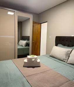 a bedroom with a bed with two towels on it at Apartamento - Leblon 409 Conforto & Estilo. in Cuiabá