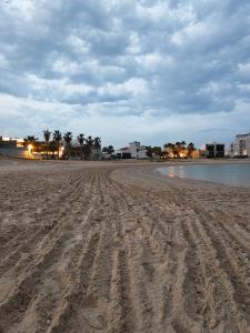 an empty beach with footprints in the sand at chalet B1 in Al Khīrān