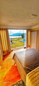 a bedroom with a large bed with a large window at Mirador el Prado in Cheqquerec