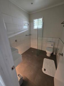 a bathroom with a toilet and a glass shower at Savusavu Terraces - Unit 2 in Savusavu +7 photos