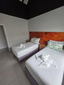 two beds in a hotel room with white walls at Savusavu Terraces - Unit 2 in Savusavu