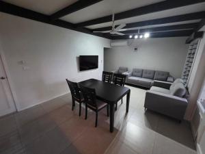 a living room with a table and chairs and a couch at Savusavu Terraces - Unit 2 in Savusavu