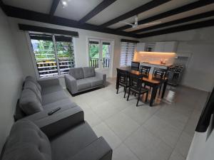 a living room with a couch and a table and a kitchen at Savusavu Terraces - Unit 2 in Savusavu