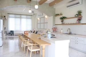 a kitchen with a table and chairs and a living room at 蘇西好日子別墅 in Sanxing
