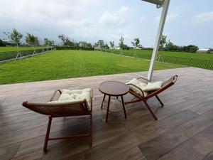 two chairs and a table with a field in the background at 蘇西好日子別墅 in Sanxing