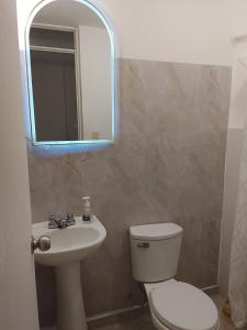 a bathroom with a toilet and a sink and a mirror at departamento familiar privado trujillo huanchaco in Huanchaco +12 photos