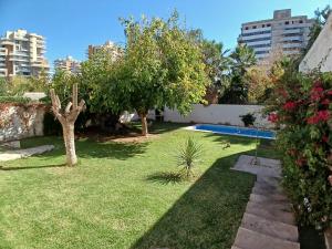 a garden with a swimming pool in a city at Mansión Palmares in Godoy Cruz