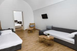 a room with two beds and a couch and a mirror at Amaryllis Suites Santorini in Fira +78 photos