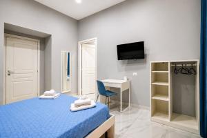 a bedroom with a bed and a desk and a television at Neve Al Sole Modern Suites near Metro Materdei in Naples Center in Naples