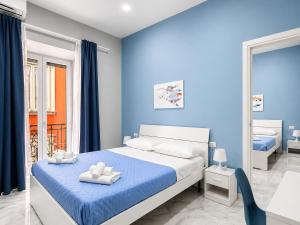 a blue bedroom with a bed with towels on it at Neve Al Sole Modern Suites near Metro Materdei in Naples Center in Naples +30 photos